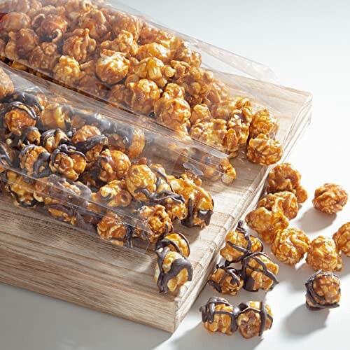 Caramel and chocolate drizzled popcorn on a wooden board