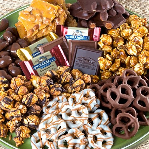 Assorted chocolates, caramel popcorn, and pretzels on a plate.