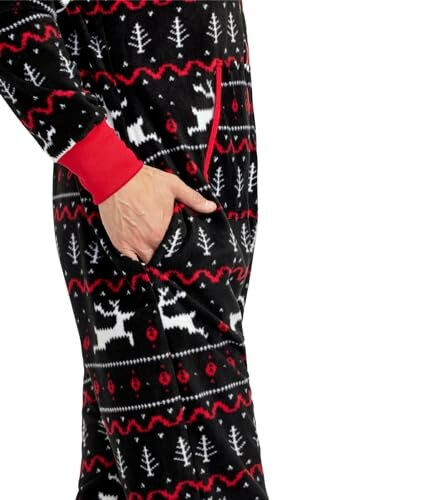 Person wearing Christmas-themed pajamas with reindeer and tree patterns