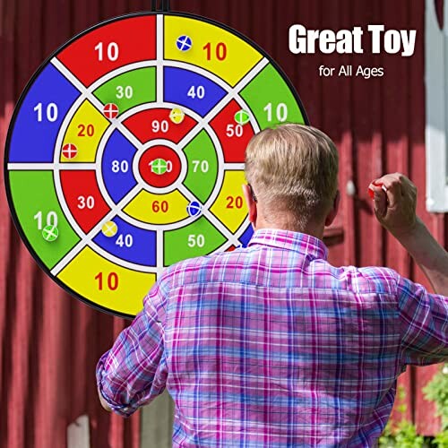 Person playing with a colorful dartboard toy mounted on a wall.