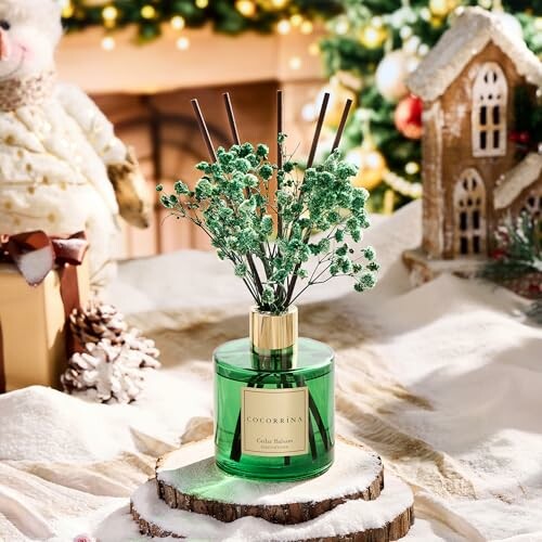 Festive scene with a green reed diffuser and holiday decorations.