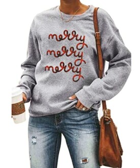 Person wearing a grey sweatshirt with 'merry' text and holding a coffee cup.