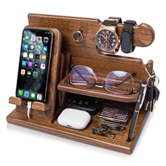 Wooden docking station with phone, watch, glasses, and accessories organized.